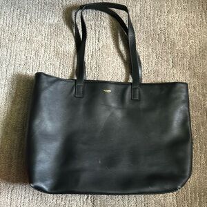 Leather Knomo tote with reinforced leather straps and exterior passport pouch.